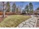 Large, lush backyard with a stone pathway, tall privacy fence, and mature trees, perfect for entertaining at 18056 E Mansfield Ave, Aurora, CO 80013