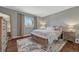 Inviting bedroom with soft lighting, hardwood floors, neutral rug and window overlooking outdoor views at 18056 E Mansfield Ave, Aurora, CO 80013