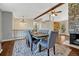 Spacious dining room with stone fireplace, wood beam, and stylish chandelier lighting at 18056 E Mansfield Ave, Aurora, CO 80013