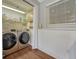 Well-equipped laundry room with modern washer and dryer, storage shelves, and ample space for laundry tasks at 18056 E Mansfield Ave, Aurora, CO 80013