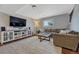 Cozy living room featuring a plush sofa, stylish entertainment center and a window letting in natural light at 18056 E Mansfield Ave, Aurora, CO 80013