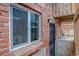 Exterior brick building with window and metal grate door entrance to basement area at 1585 S Holly St # 109, Denver, CO 80222