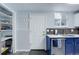 Modern kitchen with pantry/storage closet, white door and countertops, stainless steel appliances at 1585 S Holly St # 109, Denver, CO 80222