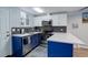 Bright kitchen with white countertops, blue cabinets, and stainless steel appliances at 1585 S Holly St # 109, Denver, CO 80222