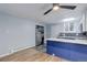 Kitchen featuring blue cabinets, white countertops, a refrigerator, and wood flooring at 1585 S Holly St # 109, Denver, CO 80222
