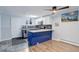 Open kitchen with modern appliances, white upper cabinets, blue lower cabinets, and ceiling fan at 1585 S Holly St # 109, Denver, CO 80222