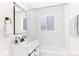 Modern bathroom with white tile, updated vanity and bathtub at 7555 E 22Nd Ave, Denver, CO 80207