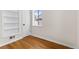 Empty bedroom showcasing hardwood floors, white walls, a built-in bookshelf, and natural light at 7555 E 22Nd Ave, Denver, CO 80207