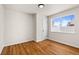 Bare bedroom featuring hardwood floors, fresh white walls, and bright window at 7555 E 22Nd Ave, Denver, CO 80207