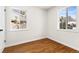 Sun-filled bedroom featuring hardwood floors, white walls, and bright double windows at 7555 E 22Nd Ave, Denver, CO 80207