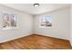 Sunlit bedroom with hardwood floors and windows overlooking the neighborhood at 7555 E 22Nd Ave, Denver, CO 80207