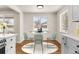Charming dining area with a round table, stylish chairs, and bright windows, perfect for Gathering meals, next to the kitchen at 7555 E 22Nd Ave, Denver, CO 80207