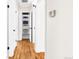 Hallway featuring hardwood floors and access to storage and rooms at 7555 E 22Nd Ave, Denver, CO 80207