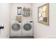 Well-equipped laundry room with modern washer and dryer, stylish shelving, and a corkboard at 7555 E 22Nd Ave, Denver, CO 80207