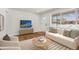 Inviting living room with hardwood floors, white furniture, and a sunny window, creating a cozy atmosphere at 7555 E 22Nd Ave, Denver, CO 80207