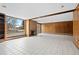 Spacious living room with a fireplace, wood paneling, and a large window at 5736 S Ivy St, Greenwood Village, CO 80111