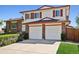 Two-story home with red shutters and a brick two-car garage, with manicured bushes at 1791 S Laredo St, Aurora, CO 80017