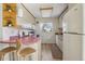 Charming kitchen features unique pink countertops, light wood cabinets, and a cozy breakfast bar area at 1791 S Laredo St, Aurora, CO 80017