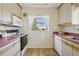 Bright kitchen with white appliances, light-colored cabinets, and a window providing natural light at 1791 S Laredo St, Aurora, CO 80017