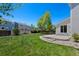 Large backyard with a green lawn, concrete patio, and privacy fence at 16256 E Otero Pl, Englewood, CO 80112