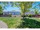 View of the green backyard with lawn, fence, and neighboring houses at 16256 E Otero Pl, Englewood, CO 80112