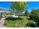 A lush backyard featuring a green lawn, mature trees, and patio at 16256 E Otero Pl, Englewood, CO 80112
