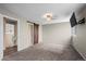 Spacious carpeted bedroom featuring a rustic barn door and mounted TV, providing a cozy retreat at 3844 S Gibralter St, Aurora, CO 80013