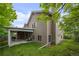 Side view of house showcases a covered patio, green lawn, and mature trees for privacy at 3844 S Gibralter St, Aurora, CO 80013