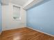 Bedroom with light blue and white walls, window with blinds, and wood floor at 225 N Lincoln St # 4, Denver, CO 80203