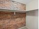 Unique closet with exposed brick wall and white shelving for storage at 225 N Lincoln St # 4, Denver, CO 80203