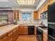 Well-lit kitchen with wooden cabinetry, stainless steel appliances, tile backsplash, and hardwood floors at 225 N Lincoln St # 4, Denver, CO 80203