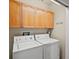 Efficient laundry room featuring a washer and dryer with wooden cabinets for storage at 225 N Lincoln St # 4, Denver, CO 80203