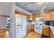 Well-lit kitchen featuring classic wood cabinetry and modern appliances for a functional cooking space at 2482 Purcell Pl, Brighton, CO 80601