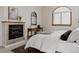 Inviting bedroom with a fireplace, a large window, and a comfortable bed, creating a relaxing and cozy atmosphere at 1035 S Elizabeth St, Denver, CO 80209