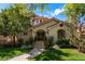 Stunning home featuring an arched entry, a brick facade, lush landscaping, and a red tile roof at 1035 S Elizabeth St, Denver, CO 80209