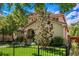 Charming home showcasing a well-manicured lawn, mature trees, and a classic wrought iron fence at 1035 S Elizabeth St, Denver, CO 80209