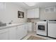 Well-lit laundry room with white cabinets, sink, and modern washer/dryer units at 1035 S Elizabeth St, Denver, CO 80209