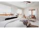 Bright main bedroom with a cozy seating area and a balcony overlooking trees at 1035 S Elizabeth St, Denver, CO 80209