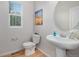 Cozy powder room with pedestal sink, framed art, and wood-look flooring at 1168 Basalt Ridge Loop, Castle Rock, CO 80108