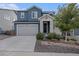 Charming two-story blue home with a stone-accented entryway and well-manicured front yard at 1168 Basalt Ridge Loop, Castle Rock, CO 80108