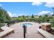 Outdoor hot tub area surrounded by mature trees, stone benches, and a sturdy fence at 1168 Basalt Ridge Loop, Castle Rock, CO 80108