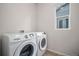 Bright laundry room featuring white Samsung washer and dryer, complemented by a window at 1168 Basalt Ridge Loop, Castle Rock, CO 80108
