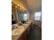 Bright bathroom with double sinks, vanity, and tile floors at 6845 S Webster St # E, Littleton, CO 80128