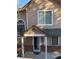 Tan two-story townhome with a covered entryway and brick facade at 6845 S Webster St # E, Littleton, CO 80128