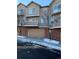 Townhome with attached garage and snow-covered street at 6845 S Webster St # E, Littleton, CO 80128