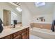 This bathroom features a soaking tub, skylights, and wood accents creating a relaxing spa-like retreat at 6487 W Weaver Ave, Littleton, CO 80123