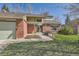 Lovely two-story home featuring a brick exterior, two-car garage and green manicured lawn at 6487 W Weaver Ave, Littleton, CO 80123