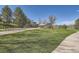 A well-maintained community playground with swings, slides, and open green space under a clear blue sky at 6487 W Weaver Ave, Littleton, CO 80123