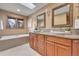 Elegant bathroom featuring double sinks, a soaking tub, and skylight at 16735 E Crestline Pl, Centennial, CO 80015