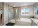 Modern bathroom with glass-enclosed shower, soaking tub, and ample natural light at 781 Deer Clover Cir, Castle Pines, CO 80108